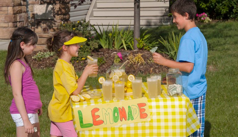 A boy selling lemonade to other children