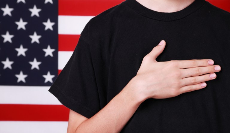 Hand on heart by American flag.