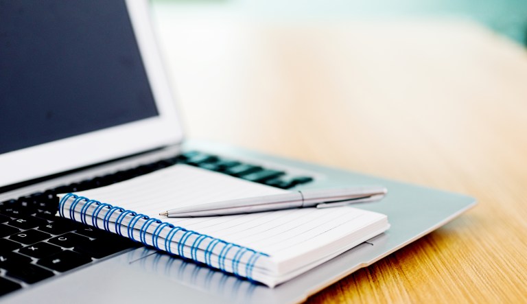 A computer with a notebook.