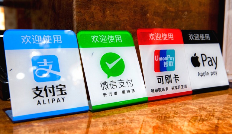 A photo taken in Shanghai, China, shows signs indicating the available electronic payment methods: Alipay, Wechat Pay, Western Union Card, and Apple Pay.