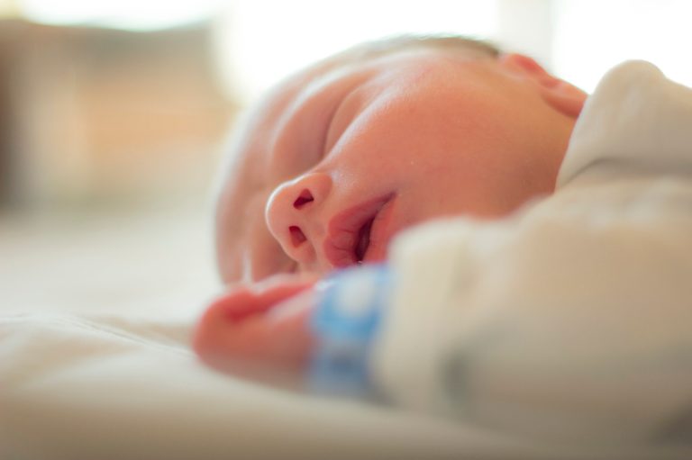 A newborn sleeps in its bed.