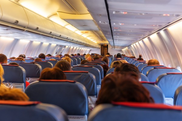 Yes, you should stand up when your plane lands
