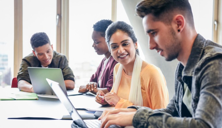 College students working on computer in classroom.