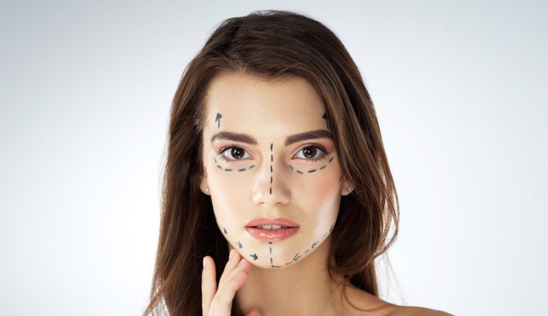 Studio shot of a young woman with plastic surgery outlines.