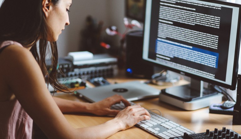 Overhead image of a young woman typing on her computer