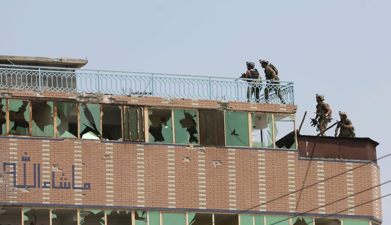 Afghan security personnel take position on the top of a building where insurgents were hiding, in the city of Jalalabad, east of Kabul, Afghanistan, Monday, Aug. 3, 2020. An Islamic State group attack on a prison in eastern Afghanistan holding hundreds of its members raged on Monday after killing people in fighting overnight, a local official said.