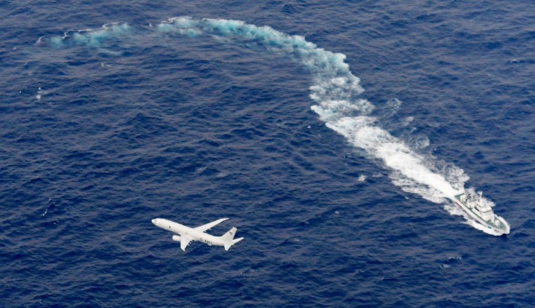In this Dec. 6, 2018, aerial photo, a Japan coast guard ship and U.S. military plane are seen at sea off Kochi, Japan, during the search-and-rescue operation for missing crew members after a U.S. Marine plane and fighter jet crashed.