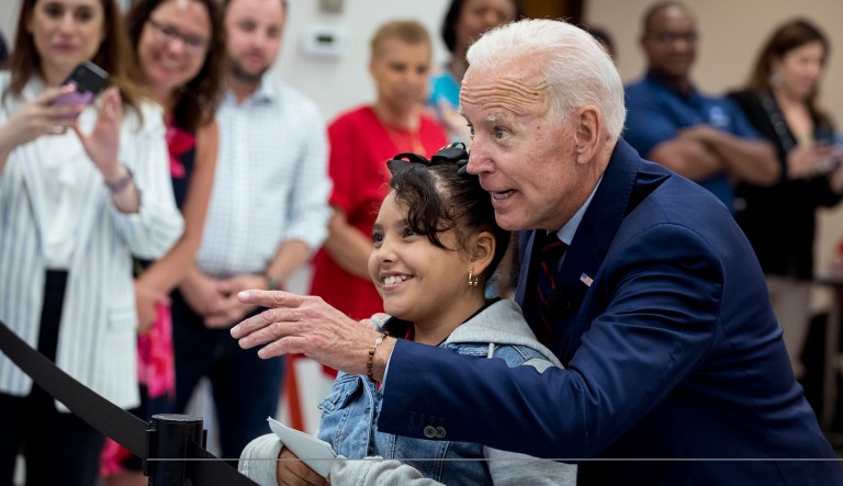 Former Vice President Joe Biden, a 2020 Democratic presidential hopeful, takes Virmania Villalobos, 10, back to introduce her to members of the media after she asked him a question during a town all meeting with a group of educators from the American Federation of Teachers on Tuesday, May 28, 2019, in Houston.