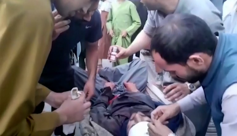 Afghan policeman comforts a man after an attack on a maternity hospital, in Kabul, Afghanistan, Tuesday, May 12, 2020. Militants stormed a maternity hospital in the western part of Kabul on Tuesday, setting off an hours-long shootout with the police and killing over a dozen people, including two newborn babies, their mothers and an unspecified number of nurses.