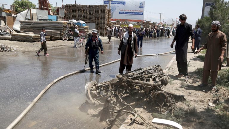 An Afghan police and people stand over the remains of a suicide attacker's vehicle in Kabul, Afghanistan, Friday, May 31, 2019, In a second suicide attack in as many days to rattle the Afghan capital, a car bomb targeting a U.S. convoy exploded early Friday morning in an eastern neighborhood, police said. 