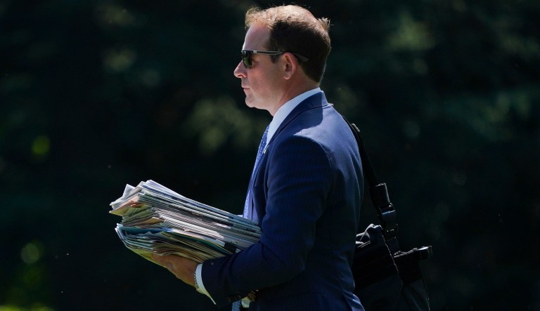 Jordan Karem, deputy assistant to the president and director of Oval Office operations, carries newspapers as he walks across the South Lawn of the White House in Washington, Friday, Aug. 24, 2018, to board Marine One helicopter for a short trip to Andrews Air Force Base, Md., en route to Columbus, Ohio. 