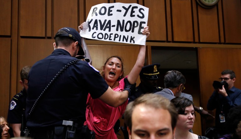 A woman stands and voices her opposition to Supreme Court nominee Brett Kavanaugh, during a Senate Judiciary Committee confirmation hearing on his nomination for Supreme Court, on Capitol Hill, Tuesday, Sept. 4, 2018, in Washington.