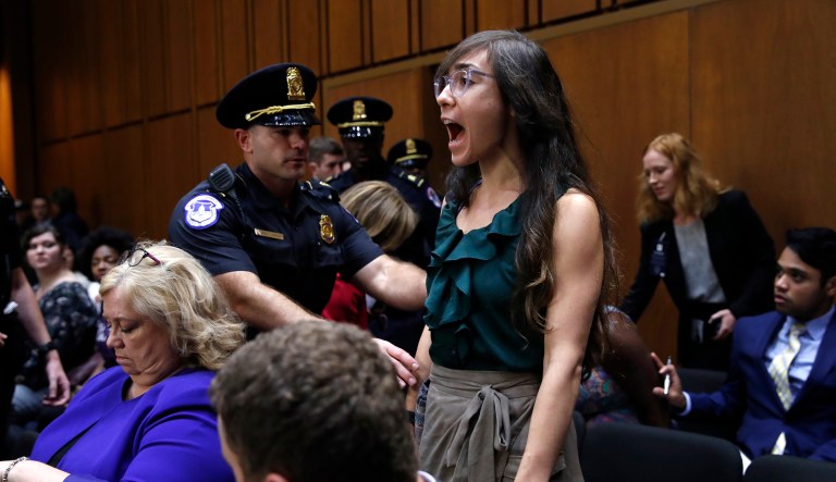 A woman stands and voices her opposition to Supreme Court nominee Brett Kavanaugh, during a Senate Judiciary Committee confirmation hearing on his nomination for Supreme Court, on Capitol Hill, Tuesday, Sept. 4, 2018, in Washington.