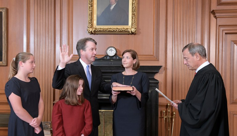 Chief Justice John Roberts, right, administers the Constitutional Oath to Judge Brett Kavanaugh in the Justices' Conference Room of the Supreme Court Building. Ashley Kavanaugh holds the Bible. In the foreground are their daughters, Margaret, left, and Liza.