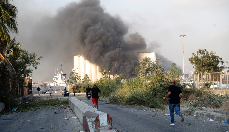 Lebanese security officers run to the explosion scene that hit the seaport of Beirut, Lebanon, Tuesday, Aug. 4, 2020. Massive explosions rocked downtown Beirut on Tuesday, flattening much of the port, damaging buildings and blowing out windows and doors as a giant mushroom cloud rose above the capital. Witnesses saw many people injured by flying glass and debris.