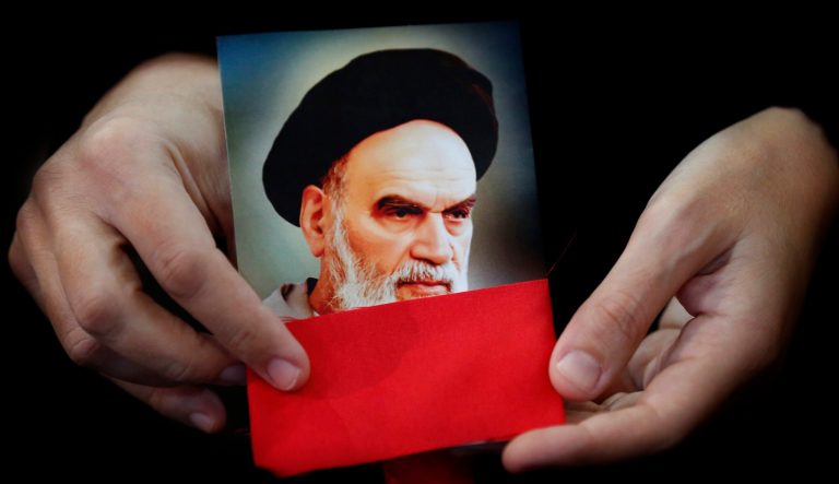 A Hezbollah supporter holds a portrait the late Iran revolutionary founder Ayatollah Ruhollah Khomeini during a rally to commemorate the 40th anniversary of Iran's Islamic Revolution, in southern Beirut, Lebanon, Wednesday, Feb. 6, 2019.