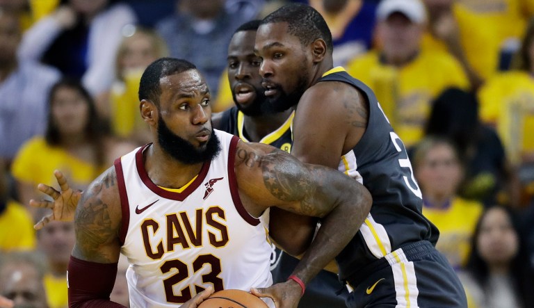 Cleveland Cavaliers forward LeBron James (23) drives against Golden State Warriors forward Draymond Green, center rear, and forward Kevin Durant during the first half of Game 2 of basketball's NBA Finals in Oakland, Calif., Sunday, June 3, 2018.