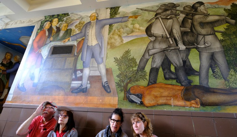 People stand in the main entryway of George Washington High School to view the controversial 13-panel, 1,600-square foot mural, the "Life of Washington," during an open house for the public Thursday, Aug. 1, 2019, in San Francisco.