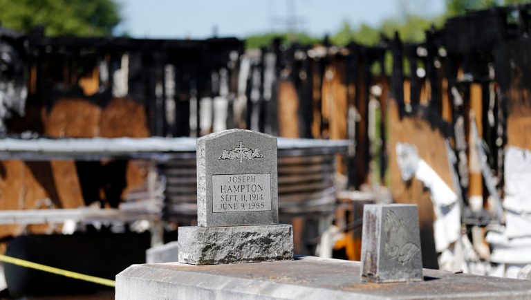 Graves from a cemetery are seen behind the burnt ruins of the Greater Union Baptist Church, one of three that recently burned down in St. Landry Parish, are seen in Opelousas, La., Wednesday, April 10, 2019. 