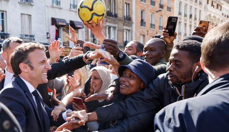 French President Emmanuel Macron shakes hands with residents during a campaign stop on April 21 in Saint-Denis, outside Paris, France. 