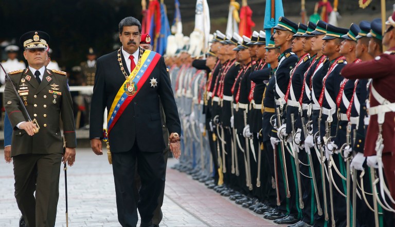 Venezuela's President Nicolas Maduro, second from left, walks with his Defense Minister Vladimir Padrino Lopez as they review to the troops during a military parade at Fort Tiuna in Caracas, Venezuela, Thursday, May 24, 2018.