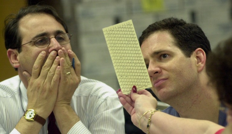 Reporter Eliot Kleinberg with the Palm Beach Post and reporter Andy Craine with the Sarasota Herald-Tribune look at a Broward County undervoted ballot during a manual recount at the Broward County elections department warehouse in Ft. Lauderdale, Fla., Tuesday Dec. 19, 2000.