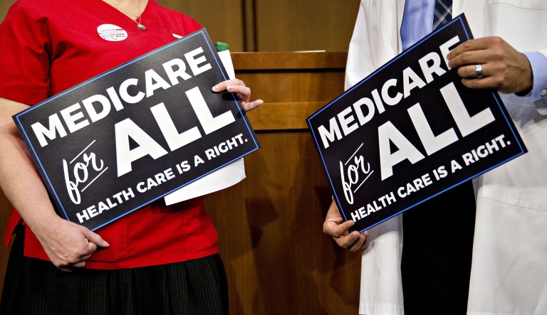 Attendees hold signs while waiting for a health care bill news conference to begin on Capitol Hill in Washington, D.C., on Wednesday, Sept. 13, 2017.