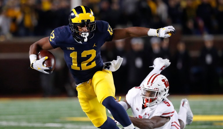 Michigan running back Chris Evans (12) shakes the tackle of Wisconsin cornerback Rachad Wildgoose (5) during the second half of an NCAA college football game in Ann Arbor, Mich., Saturday, Oct. 13, 2018.