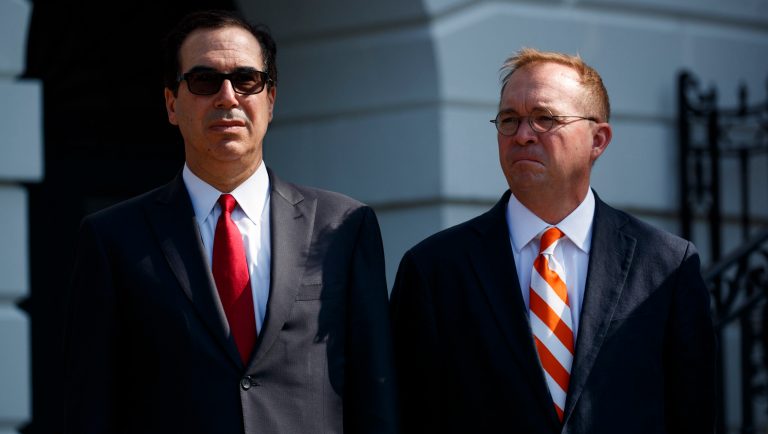 Treasury Secretary Steve Mnuchin, left, and Director of the Office of Management and Budget Mick Mulvaney listen as President Donald Trump delivers remarks about the economy on the South Lawn of the White House, Friday, July 27, 2018, in Washington. 