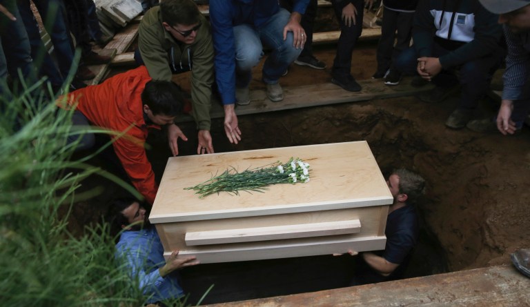 The coffin that contains the remains of 12-year-old Howard Jacob Miller Jr. is lowered into a grave at the cemetery in Colonia Le Baron, Mexico, Friday, Nov. 8, 2019, during a burial service for Rhonita Miller and four of her young children who were murdered by drug cartel gunmen. 