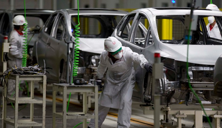 In this Feb. 21, 2014 file photo, employees at work in the new multibillion-dollar Honda car plant in Celaya, in the central Mexican state of Guanajuato.