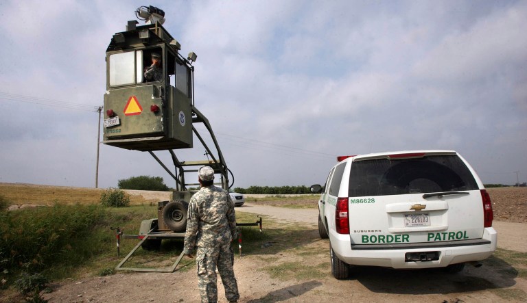 FILE - In this April 19, 2011 file photo, a member of the U.S. National Guard checks on his colleague inside a Border Patrol Skybox near the Hidalgo International Bridge in Hidalgo, Texas. National Guard members along the Texas-Mexico border assist Border Patrol by surveying the terrain from the tower. The U.S. National Guard faces a vastly different landscape than it did on its last two deployments to the Mexican border but its role is shaping up much the same: moving Border Patrol agents from behind-the-scenes jobs to making arrests on the front lines. The Guard was assigned to observation posts some distance from the border for safety reasons, using binoculars and other gear to spot people crossing. Richard Barlow, then a top Border Patrol official in San Diego, said their success as lookouts varied because they were unarmed and needed protection in more dangerous areas.