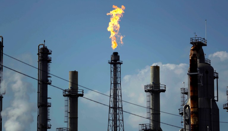 FILE - In this Thursday, Aug. 31, 2017, file photo, a flame burns at the Shell Deer Park oil refinery in Deer Park, Texas. Dry gas stations and panicked motorists are sending gasoline prices higher after Hurricane Harvey. Gas could soar to $2.75 a gallon over Labor Day weekend. Flooding from Harvey has knocked out refining capacity, and many stations in Texas are running out of fuel.