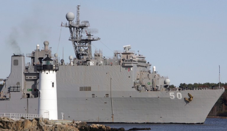 The Navy ship USS Carter Hall follows the tide out by the Porstmouth Harbor Lighthouse in New Castle, N.H., Wednesday, Nov. 4, 2009.