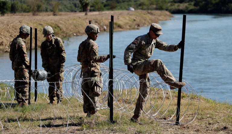 Members of the U.S. military install multiple tiers of concertina wire along the banks of the Rio Grande near the Juarez-Lincoln Bridge at the U.S.-Mexico border, Friday, Nov. 16, 2018, in Laredo, Texas.