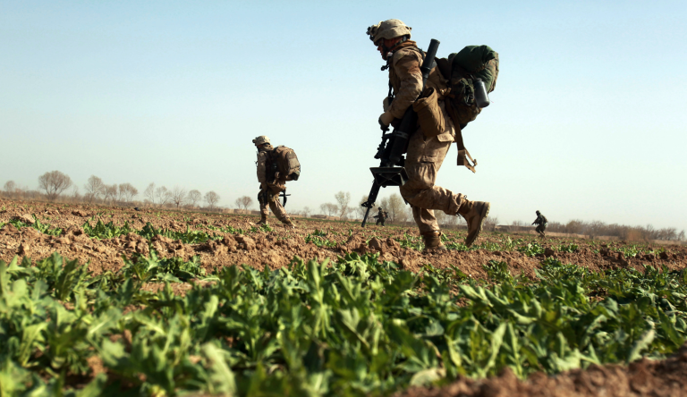 U.S. Marines from 3rd Battalion, 6th Marine Regiment advance in an open poppy field during a firefight as Taliban fighters fire on them in the town of Marjah in Afghanistan's Helmand province on Monday Feb. 15, 2010. (AP Photo/David Guttenfelder)