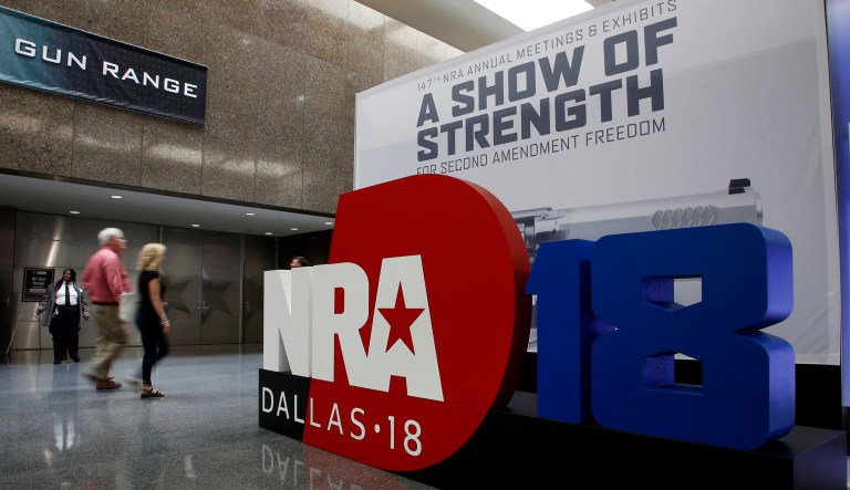 People walk by NRA convention signage in the Kay Bailey Hutchison Convention Center in Dallas, Thursday, May 3, 2018. The convention is scheduled to go through Sunday.