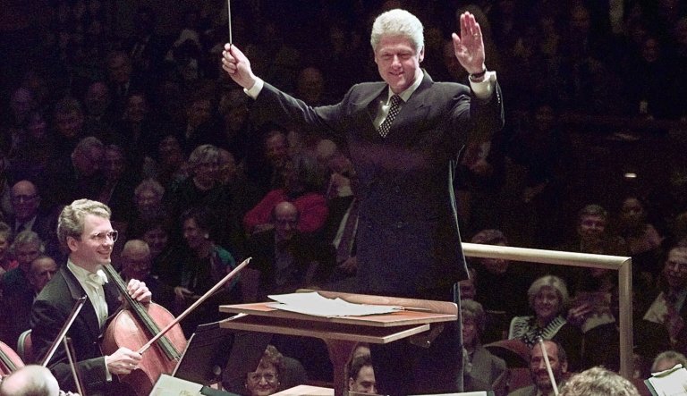 President Clinton prepares to lead the National Symphony Orchestra in a rendition of John Phillip Sousa's "Stars and Stripes Forever" to close a performance at the Kennedy Center for the Performing Arts in Washington Friday, Oct. 24, 1997. The President conducted the final encore of a performance to celebrate the re-opening of the Kennedy Center Concert Hall following extensive renovations.