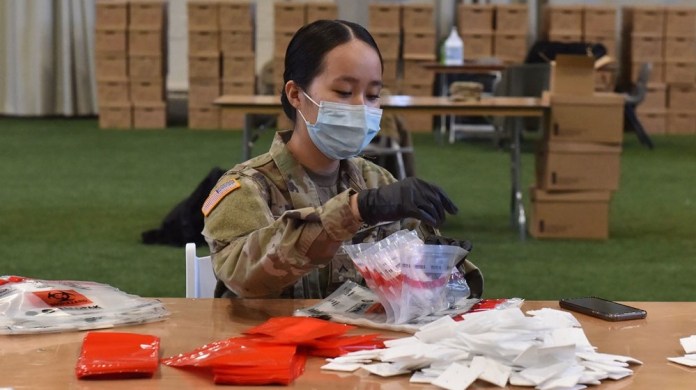 New York Army National Guard Spec. Linda Nquibn puts together a COVID-19 test kit at the Armory at Sage Colleges in Albany, N.Y. on April 11, 2020. Thirty New York Army and Air National Guardsmen are putting together COVID 19 test kits for the New York State Department of Health's Wadsworth Lab. The goal is to build 15,000 kits per day.Testing kits will be transported to testing centers all around New York State. 