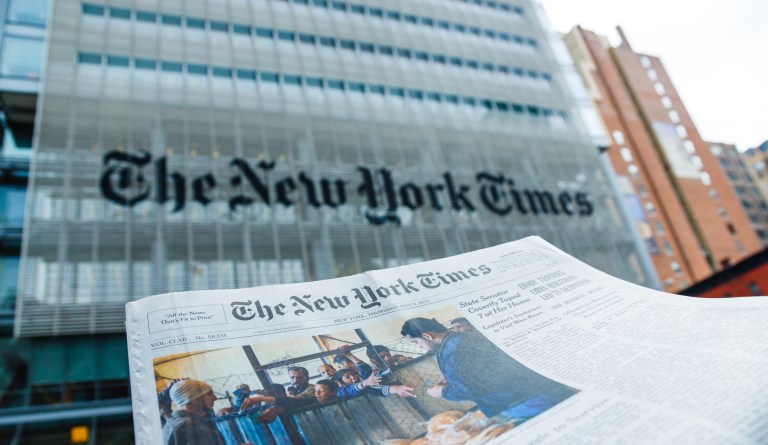 New York City, USA - May 9, 2013: A The New York Times newspaper in front of The New York Times company office building at 620 8th Avenue, Midtown Manhattan, New York City. 