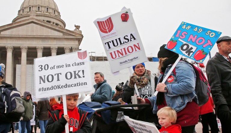 Keagan Nedrow, left, and Reed Nedrow, bottom right, stand with their mother, Tara Nedrow, right, who teaches history at Union High School, and other teachers, during a teacher rally against low school funding at the state Capitol Oklahoma City, Monday, April 2, 2018.