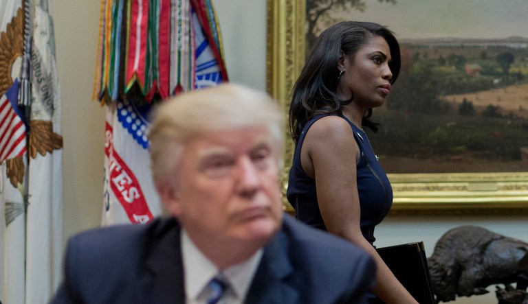 White House Director of communications for the Office of Public Liaison Omarosa Manigault, right, walks past President Donald Trump during a meeting on healthcare in the Roosevelt Room of the White House in Washington, Monday, March 13, 2017.