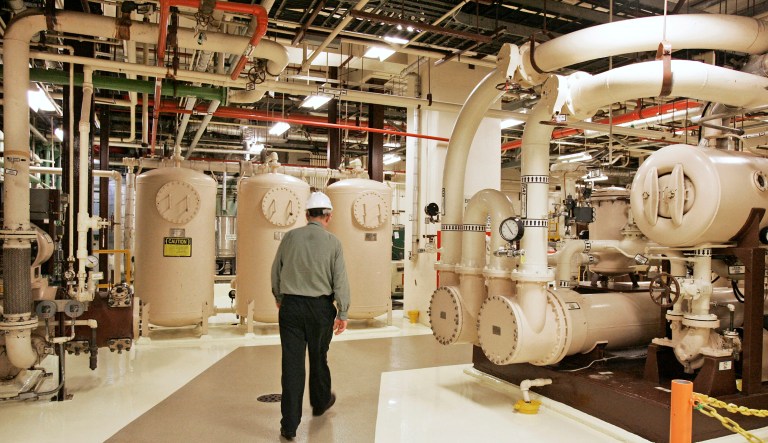 FILE â In this Feb. 25, 2010, file photo, an Exelon Corp. employee walks past equipment in the turbine building at the Oyster Creek Generating Station, a nuclear power plant in Lacey Township, N.J.