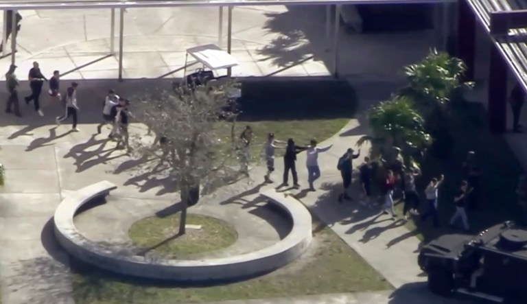 Students from the Marjory Stoneman Douglas High School in Parkland, Fla., evacuate the school following a shooting there on Wednesday, Feb. 14, 2018. (WPLG-TV via AP)