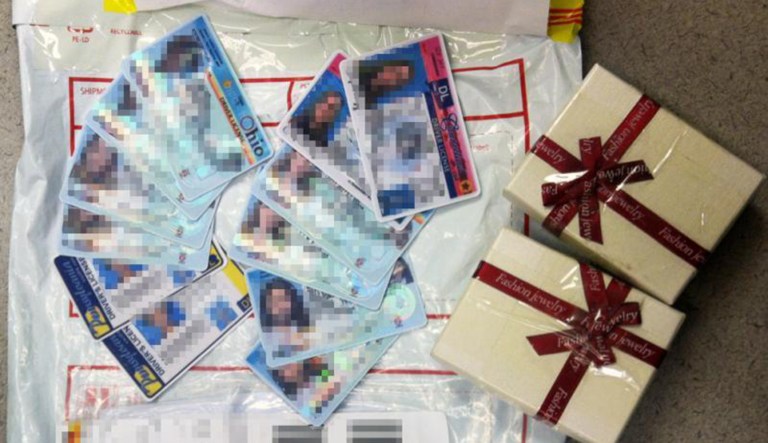 Confiscated fake IDs, with faces blurred out, are shown next to some packaging.