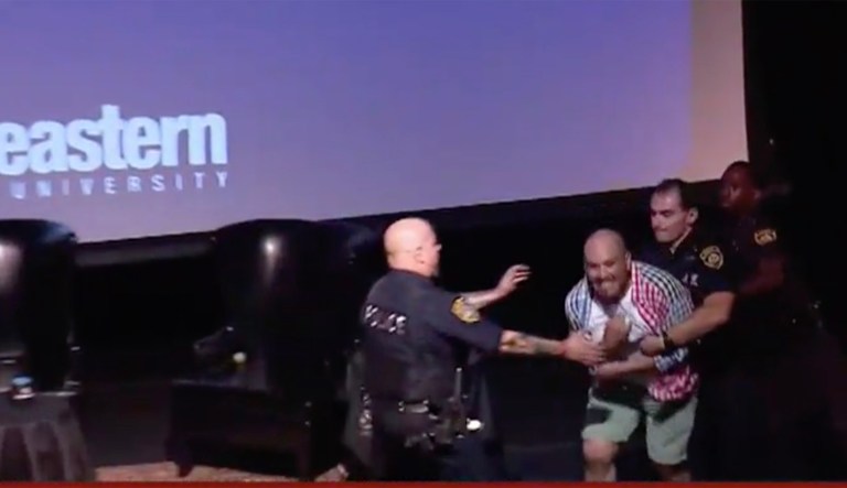 Police rush stage to take down protester at Sean Spicer event