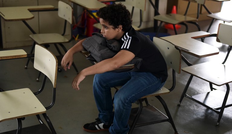 In this Friday, Oct. 13, 2017 photo, a student sits alone in a classroom at Ramon Marin Sola Elementary School, which opened its doors as a daytime community center after the passing of Hurricane Maria in Guaynabo, Puerto Rico. Because Hurricane Maria followed closely after Hurricane Irma, students have had only about six weeks of class since the academic year started Aug. 14.