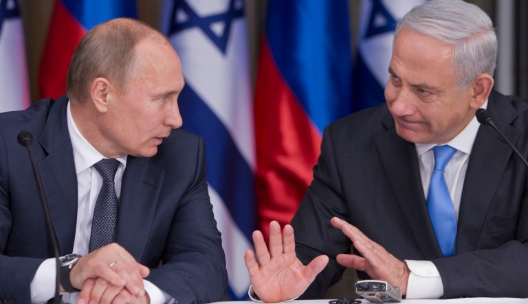 Russian President Vladimir Putin listens to Israeli Prime Minister Benjamin Netanyahu.