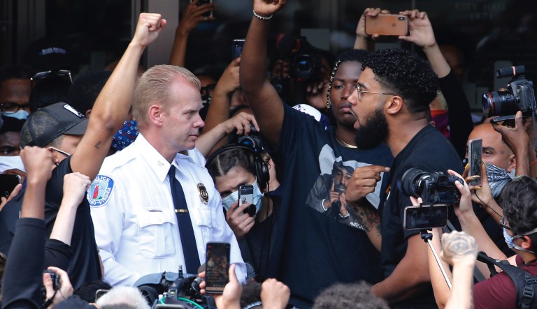 Richmond Police Chief William Smith, left, is confronted by a protester as he attempts to address a large crowd in front of City Hall, Tuesday June 2, 2020, in Richmond, Va.  Richmond Mayor Levar Stoney apologized after police, the night before, lobbed tear gas at a group of peaceful demonstrators during a protest over the death of George Floyd, who died after being restrained by Minneapolis police officers on May 25.