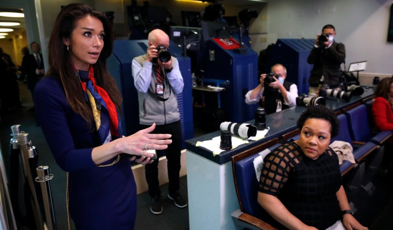 PBS reporter Yamiche Alcindor, seated, watches as One America News (OAN) White House Correspondent Chanel Rion asks a question of President Donald Trump during a briefing about the coronavirus in the James Brady Press Briefing Room of the White House, Monday, April 20, 2020, in Washington.
